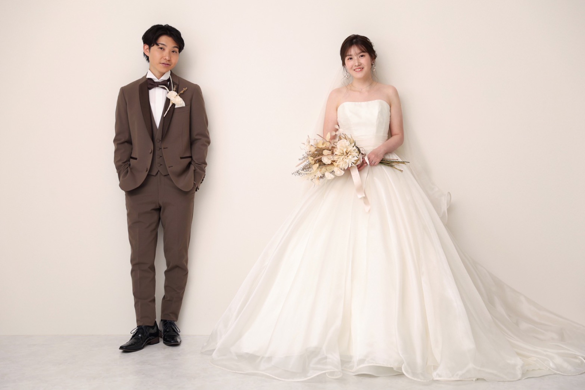 並んで立つウェディングドレスとタキシードの新郎新婦(スタジオでの撮影例)